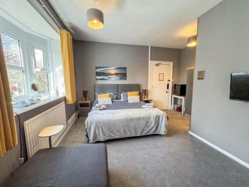a bedroom with a bed and a couch in it at Torwood House in Penzance