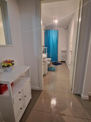 a bathroom with a toilet and a blue shower curtain at Ricky-Lerua Holiday Residence in Florence