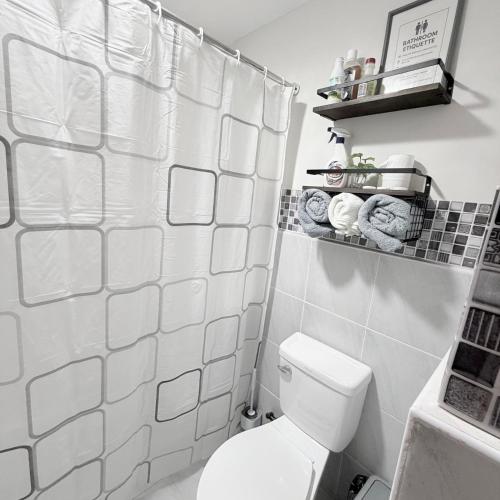a white bathroom with a toilet and a shower at Skyline Studio Marigondon in Marigondon