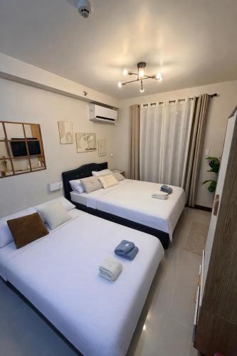 two beds in a room with white sheets at Skyline Studio Marigondon in Marigondon