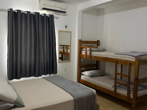 a room with two bunk beds and a window at Apartamento Sunset 101 in Palhoça