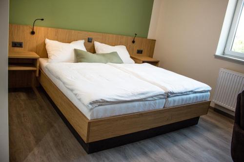 a bedroom with a large bed with white sheets at Bärenhof in Matzen
