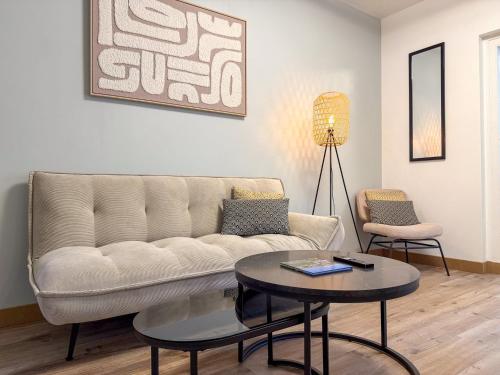 a living room with a couch and a table at Les Volets Bleus in Chartres
