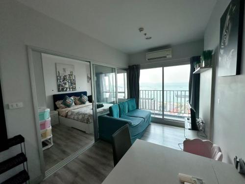 a living room with a couch and a bed and a window at Pattaya Sea View Condo in Pattaya