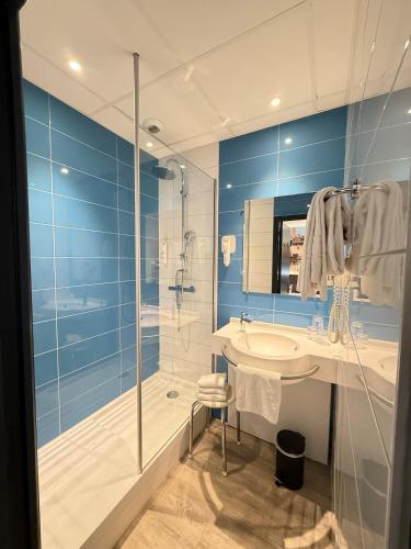 a bathroom with a glass shower and a sink at The Originals City, Hôtel Le Boeuf Rouge, Saint-Junien in Saint-Junien
