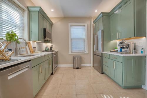 a kitchen with green cabinets and a tile floor at Brooklyn Gem 3 Blocks to Prospect Park - 3 King Beds 1 Queen, Free parking, in Brooklyn