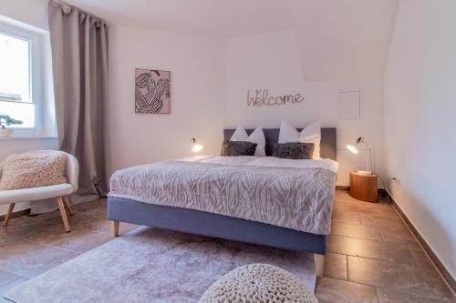 a bedroom with a bed and a sign that reads welcome at Innenhof-Quartier in Meerane