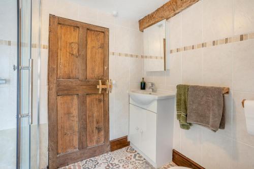a bathroom with a sink and a wooden door at 2 Bed in Defynnog oc-t32724 in Sennybridge