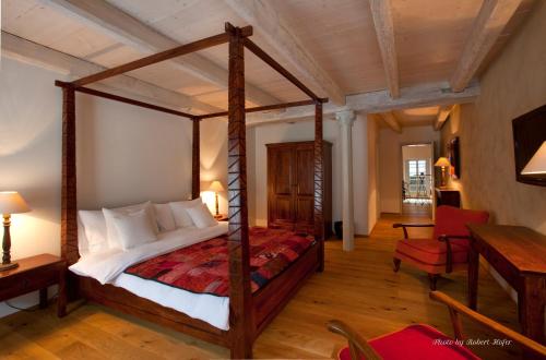 a bedroom with a canopy bed in a room at Le Jardin de Kabir in Martigny-Ville