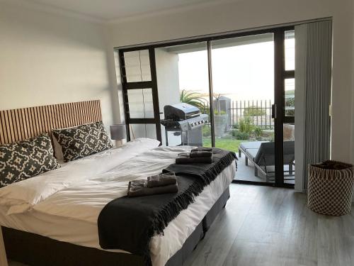 a bedroom with a large bed with towels on it at The Tarp at Whale Cove in De Kelders