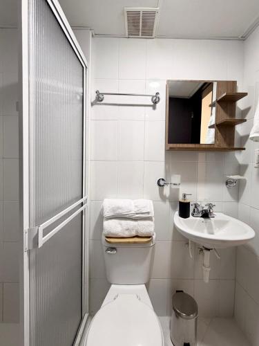 a white bathroom with a toilet and a sink at Espacio cómodo, piscina, jacuzzi y parqueadero in San Gil