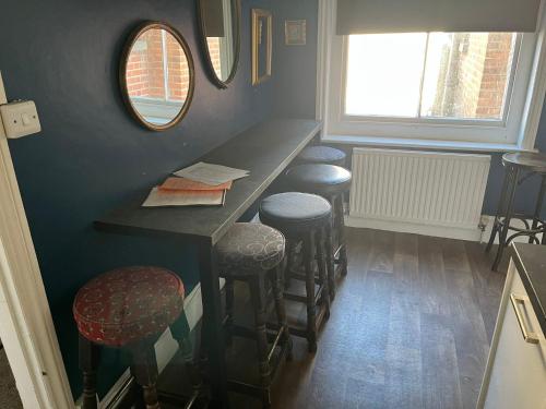 a bar in a room with stools and a counter at Corner House Apartment in Worthing
