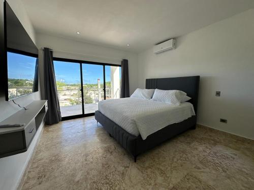 a bedroom with a bed and a large window at Arena Aparta Hotel in Punta Cana