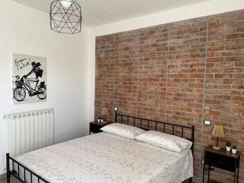 a bedroom with a brick wall and a bed at NEpicentro2 in Nepi