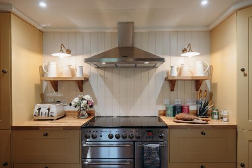 a kitchen with a stove and a hood at Muir Cottage in Aboyne