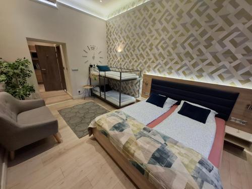 a bedroom with a bed and a chair and a desk at Révay 6 Suites by Corall in Budapest
