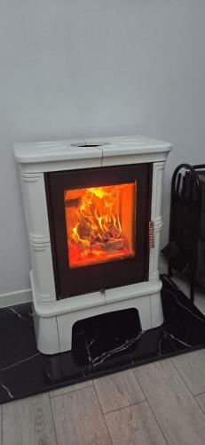 a white stove with a fire inside of it at Apartament z kominkiem RetroGlam in Mieroszów