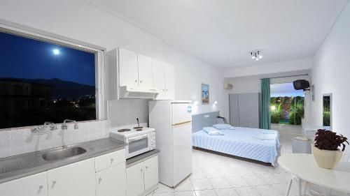 a kitchen with a sink and a bed and a window at Galazia Akti in Agios Nikolaos