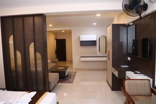 a living room with a couch and a television at Elara Residency Cheravathur in Cheruvattūr