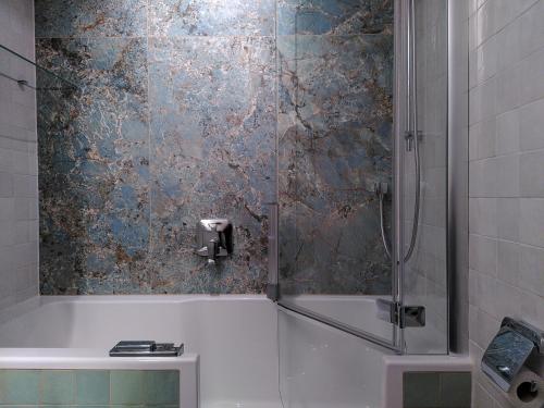 a bathroom with a shower and a bath tub at Refugium.311 in Bad Reichenhall