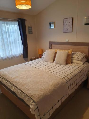 a bedroom with a large bed with pillows at Jasper Lodge in Morecambe