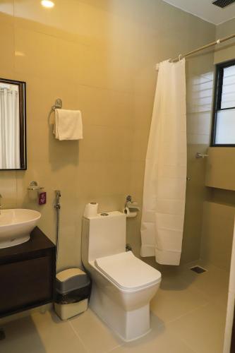 a bathroom with a white toilet and a sink at Le Casa Villa by hotel travel inn in Pokhara