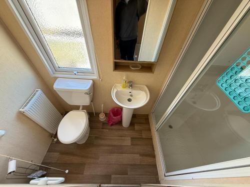 a small bathroom with a toilet and a sink at Sleeps 8 guests lovely 3 Bedroom Golden Gate Towyn in Llanddulas