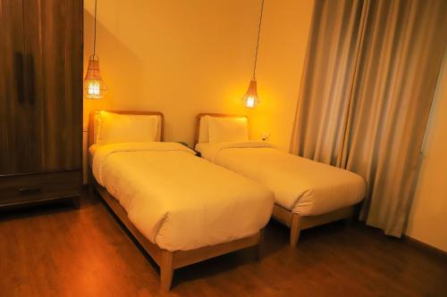 two beds in a hotel room with lights at Le Casa Villa by hotel travel inn in Pokhara
