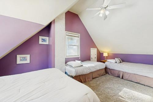 a bedroom with two beds and a purple wall at Sugarbush River Home in Warren