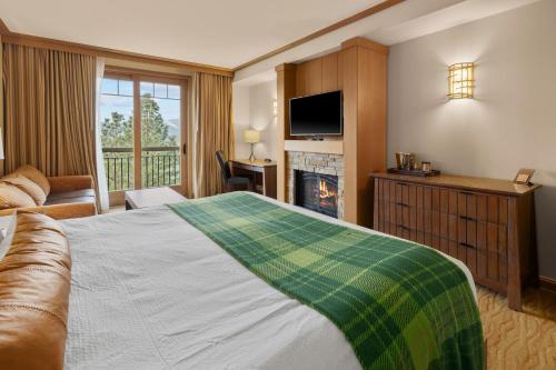 a hotel room with a bed and a couch and a fireplace at 3033 Suncadia Riverfront Studio Lodge Pool Access in Cle Elum