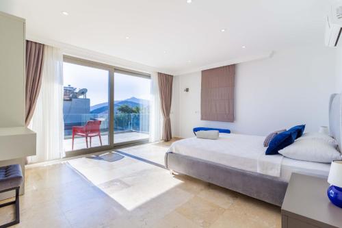 a bedroom with a bed and a large window at Villa Gunes in Kalkan