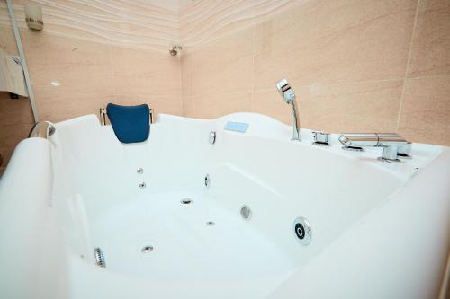 a white bath tub in a bathroom with a sink at La Villa Tombouctou in Bingerville