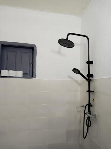 a bathroom with a shower with a light on the wall at Iroko Plage San Pédro in San-Pédro