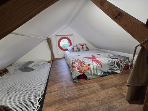 a bedroom with two beds in a attic at la cabane de la régalante in Rannée