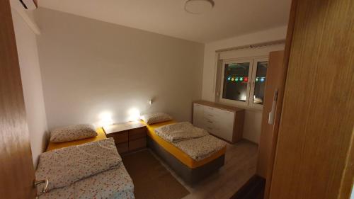a small room with two beds and a window at Happy Corner in Varaždin