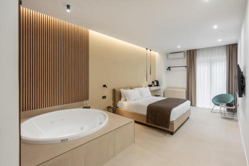 a bedroom with a bed and a tub in a room at Cali Luxury Suites in Caserta