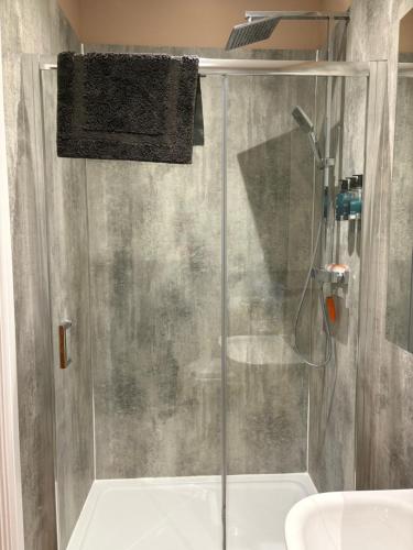 a shower with a glass door in a bathroom at The Cow 'ouse, Wolds Way Holiday Cottages, 1 bed cottage in Little Weighton