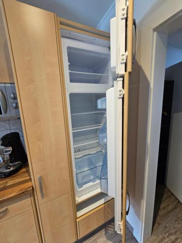 an empty refrigerator with its door open in a kitchen at 84m2 Ferienwohnung - Landquartier Moik Ankommen - Durchatmen - Abschalten in Ebenthal