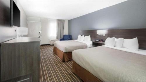 a hotel room with two beds and a sink at Downtown Inn & Studio Suites in Memphis