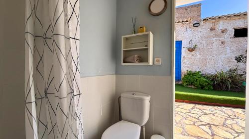 a bathroom with a toilet and a wall at MarketHome Ecolodge Plataneras 2 in Chío