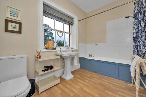 a bathroom with a sink and a tub and a toilet at Finest Retreats - Clavering Hall in Saffron Walden
