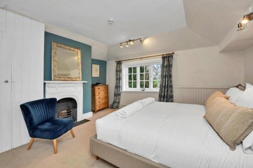 a bedroom with a white bed and a blue chair at Finest Retreats - Clavering Hall in Saffron Walden