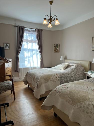a bedroom with two beds and a window at B&B Chez Hubert in Quebec City
