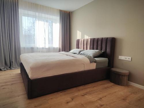 a bed in a bedroom with a large window at Manere commoda in Šiauliai