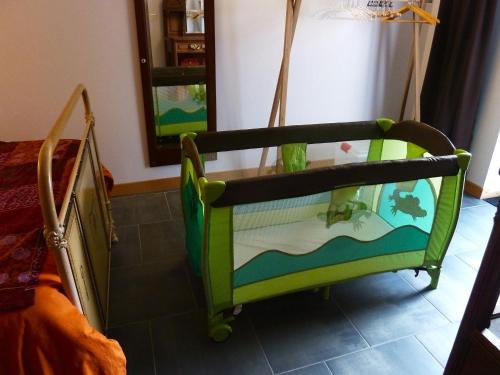 a crib with a table on it in a room at Gîte Chez Dimanche in Essert