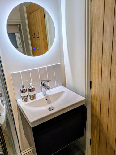 a bathroom with a sink and a mirror at Pudsey Loft Apartment in Pudsey