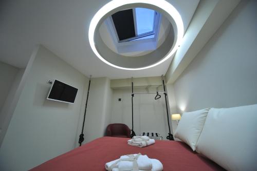 a bedroom with a bed with a round mirror at Gatto Bianco House in Bari