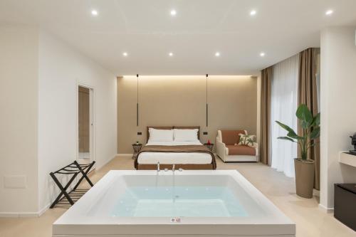 a bathroom with a bath tub in front of a bed at Cali Luxury Suites in Caserta