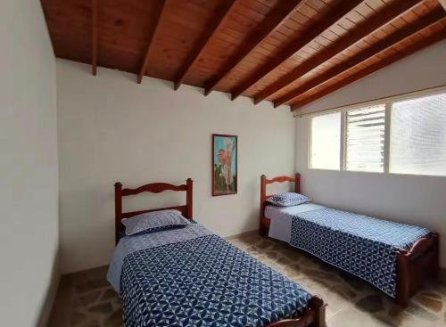 a bedroom with two beds and a window at Hostel La Casona in Medellín