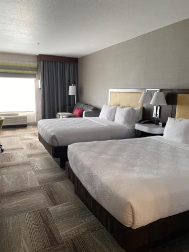 a hotel room with two beds and a couch at Country Inn & Suites by Radisson, Idaho Falls at the Mall in Idaho Falls